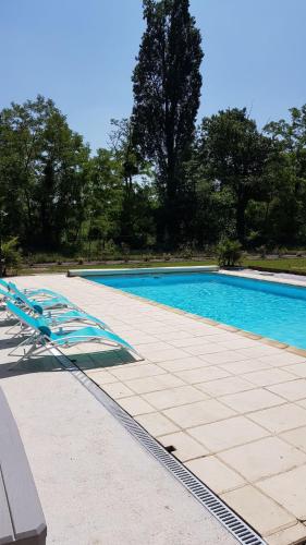 une piscine avec des chaises longues à côté dans l'établissement Gîte Les Sables calme proche Zoo de Beauval & Châteaux, avec piscine, à Mareuil-sur-Cher