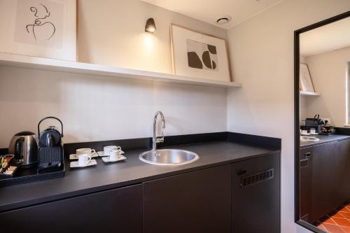 a kitchen with a sink and a counter top at Les Manoirs des Portes de Deauville - Small Luxury Hotel Of The World in Deauville