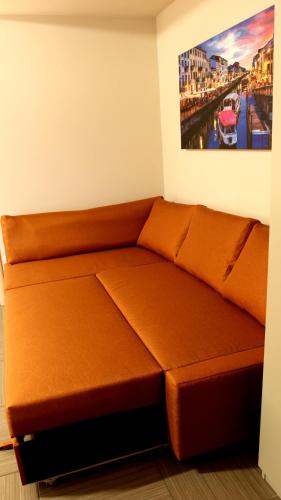 a brown couch in a room with a painting on the wall at Oasi Brembate Bed and Breakfast in Brembate