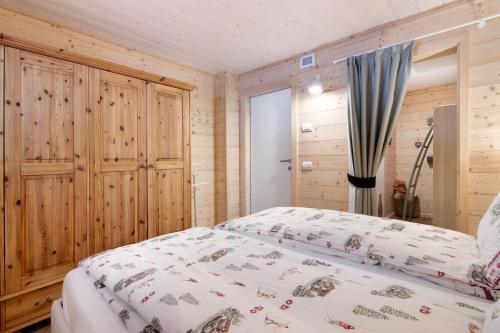 a bedroom with a bed and a wooden wall at A casa di Anna in Madesimo