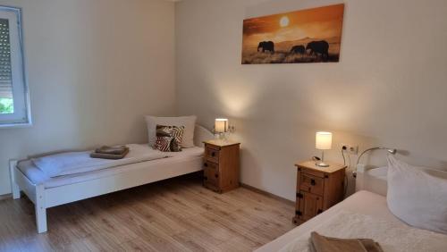 Un dormitorio con una cama y dos mesitas de noche con lámparas. en Fiore Gästezimmer, en Michelrieth