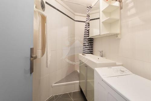 une salle de bain blanche avec un lavabo et des toilettes dans l'établissement AS21116 - P2 centre ville dans une résidence à 200m de la plage, au Grau-du-Roi
