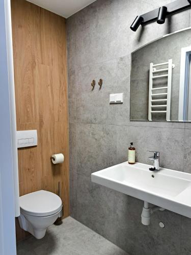 un baño con lavabo e inodoro en Sympo Apartments, en Cracovia