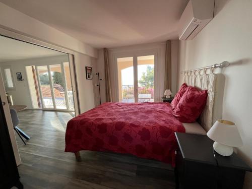 - une chambre avec un lit doté d'un couvre-lit rouge dans l'établissement Bas de villa, vue mer, terrasse, clim, piscine, à Toulon