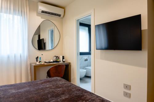 a hotel room with a bed and a mirror at Hera Rooms and Suites in Agrigento