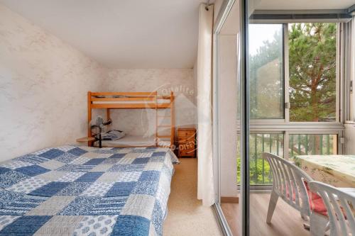 une chambre avec un lit, une table et une fenêtre dans l'établissement AS20399 - P2 centre ville avec parking privatif dans une résidence à 150m de la plage, au Grau-du-Roi