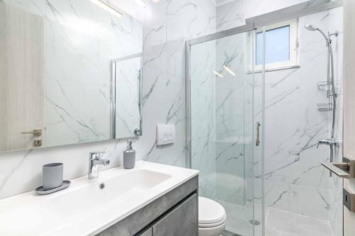 a bathroom with a sink and a glass shower at Villa Anastazia in Koskinou
