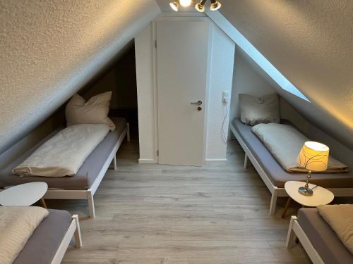 a attic room with two beds and a door at Ferienhaus Sonnenzauber 2 in Walsrode