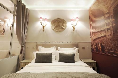 une chambre avec un grand lit blanc avec deux oreillers dans l'établissement Palais royal apartment, à Paris