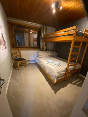 une chambre avec un lit superposé et une chaise dans l'établissement Courchevel Moriond 1650 - 2 Bedrooms - Sleeps 8, à Courchevel