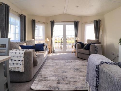 a living room with a couch and two chairs at 17 Birchwood Close in Brown Moss Side