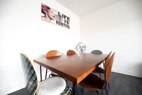 une salle à manger avec une table et des chaises en bois dans l'établissement CIA - Pereire, Spacious Flat with Balcony, à Paris