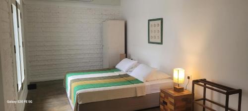 a bedroom with a bed and a lamp on a table at Olu Beach Villa in Ambalangoda