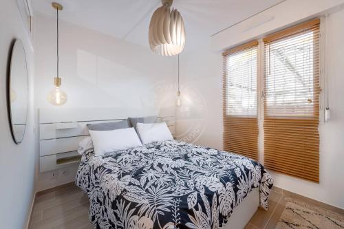 une chambre avec un lit avec une couverture noire et blanche dans l'établissement AS20113 - P2 Cabine, jardin avec belle vue sur le chenal et les bateaux, au Grau-du-Roi