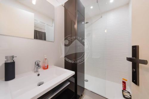 une salle de bain avec un lavabo blanc et une douche dans l'établissement AS20113 - P2 Cabine, jardin avec belle vue sur le chenal et les bateaux, au Grau-du-Roi
