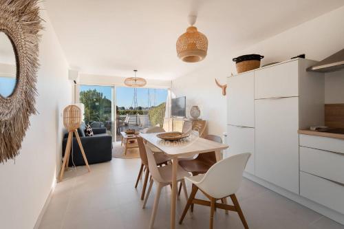 une cuisine et une salle à manger avec une table et des chaises dans l'établissement AS20113 - P2 Cabine, jardin avec belle vue sur le chenal et les bateaux, au Grau-du-Roi