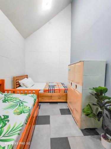 a bedroom with two beds and a potted plant at Mountain Sunctuary-HS Solo Unit for friends and family in Baguio