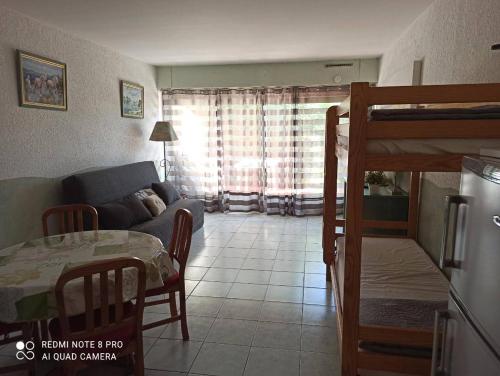 un salon avec un canapé et une table dans l'établissement AS20085 - Studio spacieux avec piscine et parking commun, au Grau-du-Roi