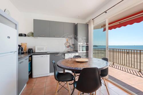 Il dispose d'un balcon et d'une cuisine avec une table et des chaises. dans l'établissement AS18069 - P3 Vue Mer exceptionnelle , sur la plage à 2 pas du Centre Ville, au Grau-du-Roi