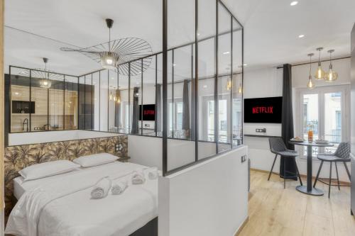 une chambre avec un grand lit blanc et une table dans l'établissement Hypercentre Studio East à 2minutes du Palais des Festivals, à Cannes