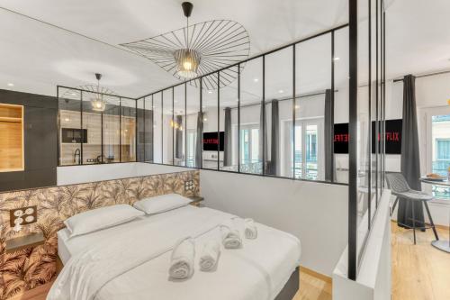 - une chambre dotée d'un grand lit blanc avec des chaussures dans l'établissement Hypercentre Studio East à 2minutes du Palais des Festivals, à Cannes