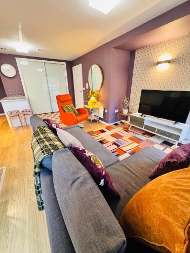 a living room with a couch and a flat screen tv at #12 Stylish Canalside Loft with Parking in Coventry