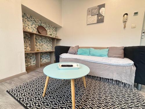 un salon avec un canapé et une table dans l'établissement Mini Mosaïque Parking Un Séjour à Part, à Longeville-lès-Metz