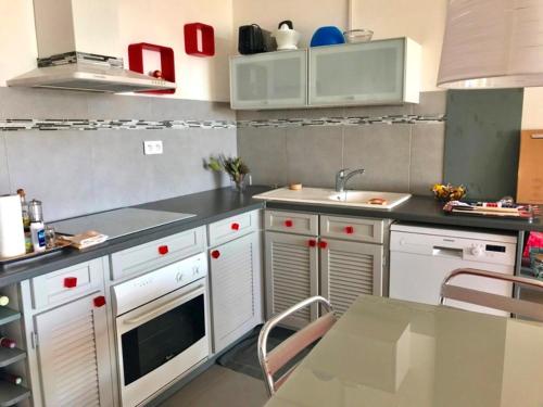- une cuisine avec des placards blancs, un évier et une table dans l'établissement AS13993- P2 Vue mer avec piscine direct sur plage, au Grau-du-Roi