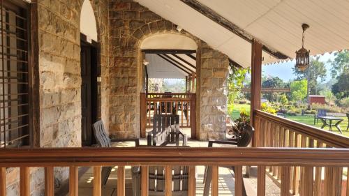 a porch of a stone building with chairs on it at Madhuvan Retreat Resort Amba in Chandoli
