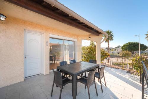 une table et des chaises en bois sur une terrasse dans l'établissement AS19003- P4 à 400m de la plage avec garage 2 voitures, au Grau-du-Roi