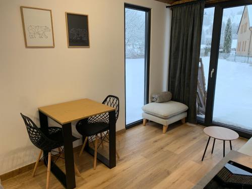 un soggiorno con tavolo, sedie e finestra di Tiny House Krkonose a Mladé Buky