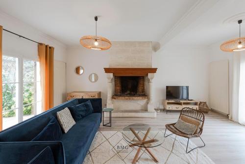 un salon avec un canapé bleu et une cheminée dans l'établissement Villa Vergers Disneyland BMYGUEST, à Serris