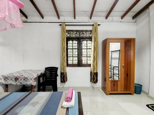 een woonkamer met een tafel en een raam bij Mango Shade Weligama in Weligama