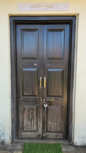 a pair of wooden doors on a building at Madhuvan Retreat Resort Amba in Chandoli