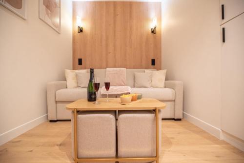 - un salon avec un canapé et une table avec des verres à vin dans l'établissement CIA - Rue de l'Étoile Haven, 4P, à Paris