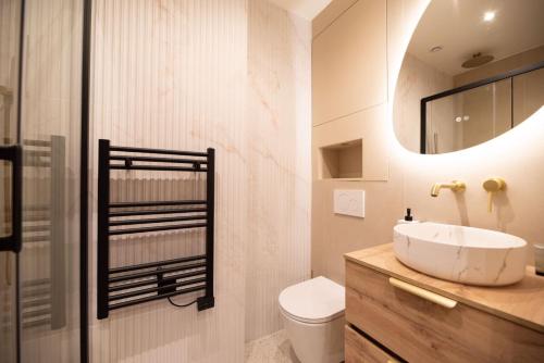 une salle de bain avec un lavabo, des toilettes et un miroir dans l'établissement CIA - Rue de l'Étoile Haven, 4P, à Paris
