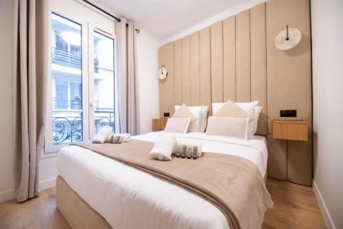 une chambre avec un grand lit avec une grande fenêtre dans l'établissement CIA - Rue de l'Étoile Haven, 4P, à Paris