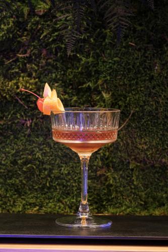 a drink in a glass with a flower in it at Hotel Medinblu in Reggio Calabria