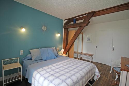 a bedroom with a large bed with blue walls at Chez doussaud in Bessines-sur-Gartempe