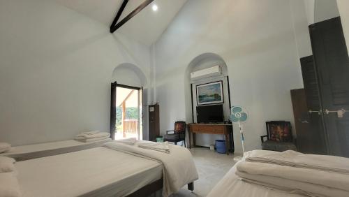 a bedroom with two beds and a television in it at Madhuvan Retreat Resort Amba in Chandoli