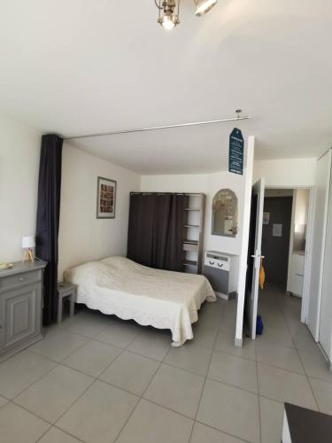 une chambre avec un lit et une commode dans l'établissement AS18656 - Grand studio vue mer, direct sur plage avec parking privé, au Grau-du-Roi