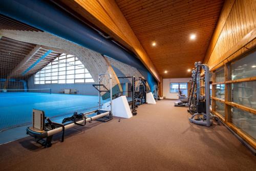 a gym with several treadmills and a swimming pool at Sporthotel Teresa in Badia