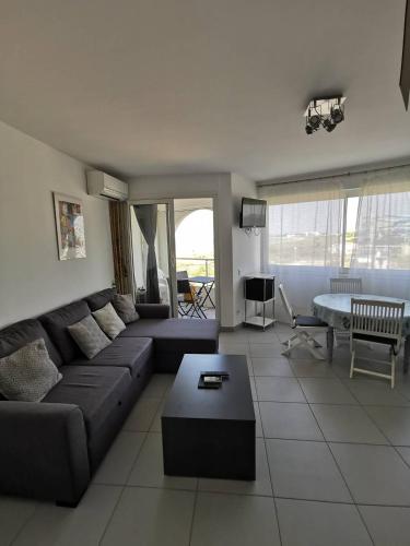 un salon avec un canapé et une table dans l'établissement AS18656 - Grand studio vue mer, direct sur plage avec parking privé, au Grau-du-Roi