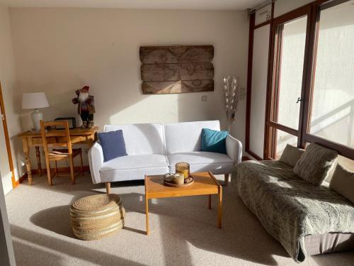 un salon avec un canapé et une table dans l'établissement Auron, steps from central square, à Auron