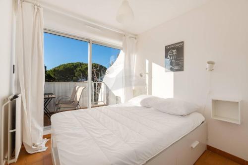 une chambre blanche avec un lit et une grande fenêtre dans l'établissement AS11677 - Marina de type p3 avec parking privé et appontement, au Grau-du-Roi