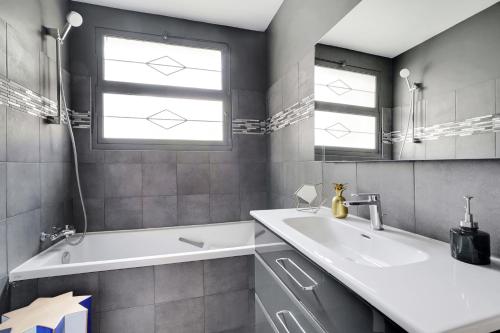 La salle de bains est pourvue d'un lavabo, d'une baignoire et d'une fenêtre. dans l'établissement Lumineux 3P spacieux & chaleureux - Hôpital américain, à Neuilly-sur-Seine