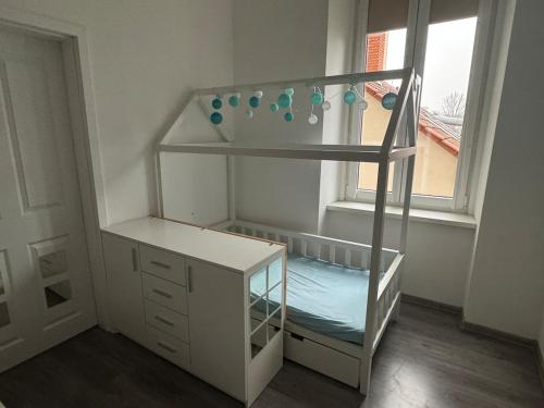a white bunk bed in a room with a window at V centru Znojma s vybavením pro děti a garáží pro kola in Znojmo