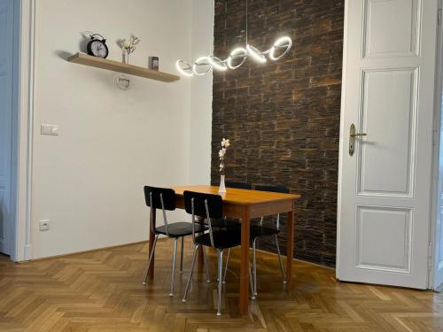 a dining room table with black chairs and a chandelier at V centru Znojma s vybavením pro děti a garáží pro kola in Znojmo