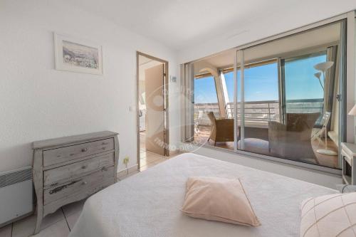 une chambre avec un lit et une grande fenêtre dans l'établissement AS9836 - P2 dans une résidence sur la plage avec belle vue sur le chenal et parking privé, au Grau-du-Roi