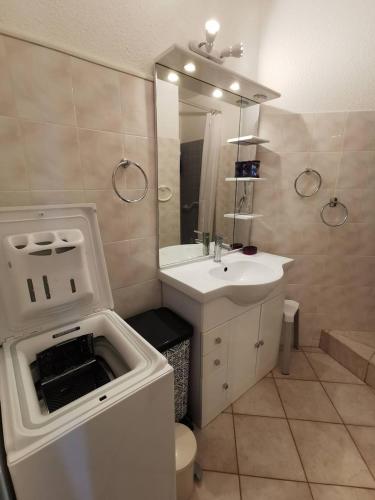 une salle de bain avec un lavabo, des toilettes et un miroir dans l'établissement AS16106 - Studio centre ville avec parking privé, au Grau-du-Roi